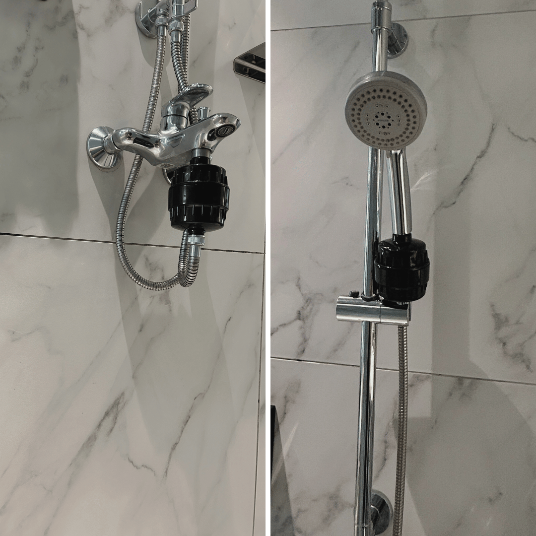 Close-up of a chrome shower fixture and handheld showerhead against a marble wall.